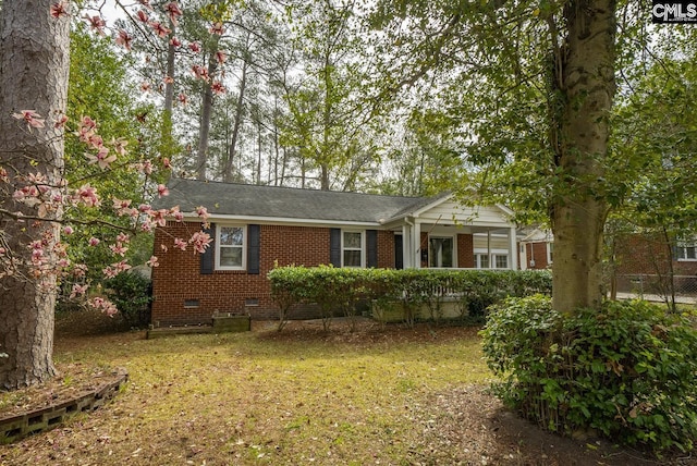 view of front of house with a front lawn, brick siding, and crawl space