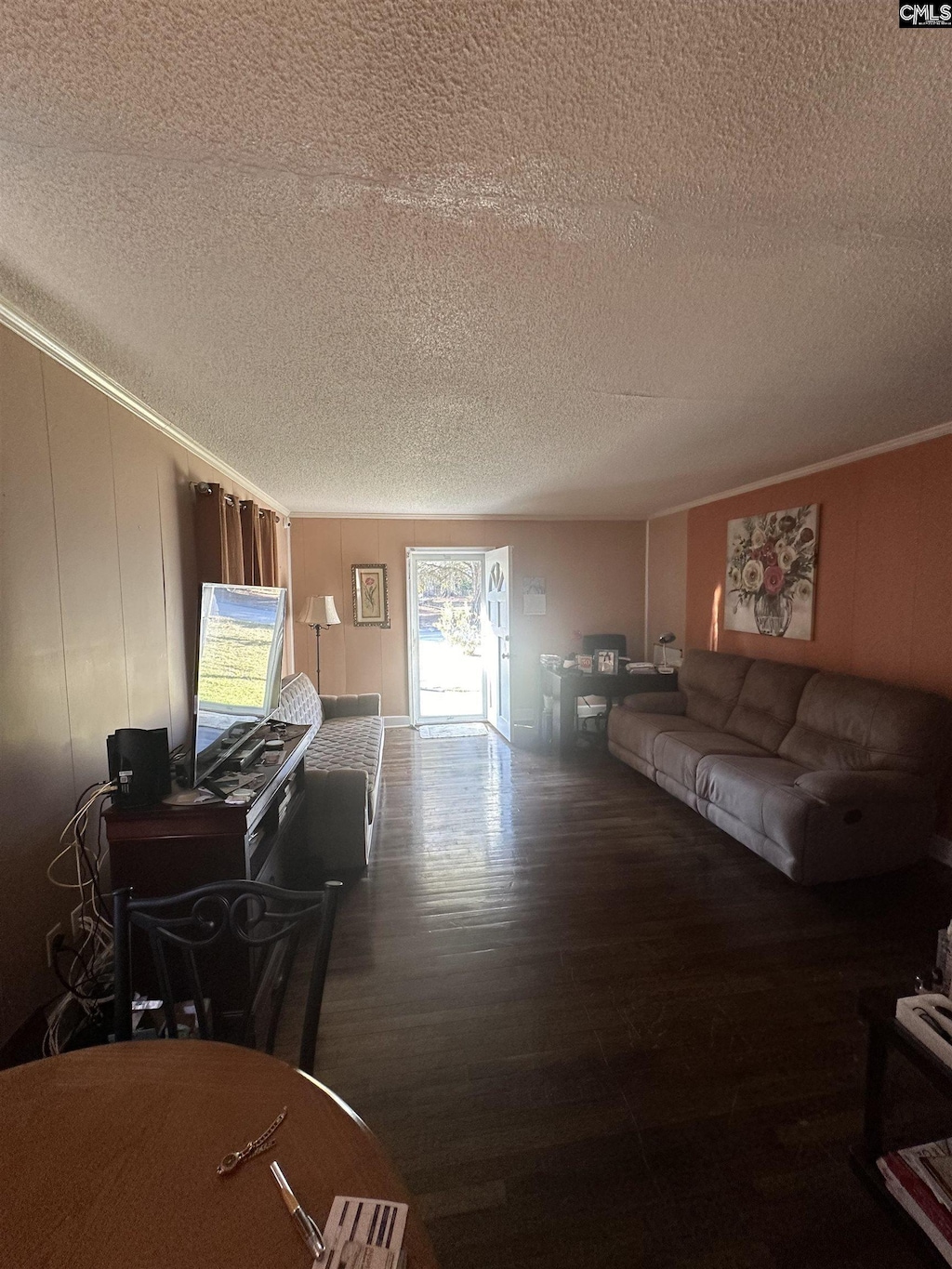 living area featuring a textured ceiling, crown molding, and wood finished floors