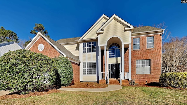 traditional-style home with brick siding and a front yard