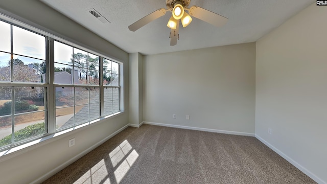 spare room with visible vents, ceiling fan, baseboards, and carpet