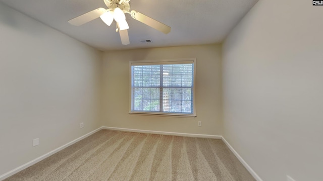 carpeted empty room featuring visible vents, ceiling fan, and baseboards