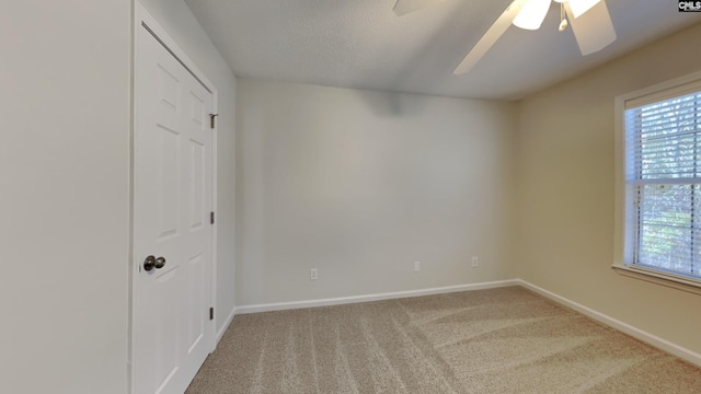 carpeted spare room with baseboards, a textured ceiling, and ceiling fan