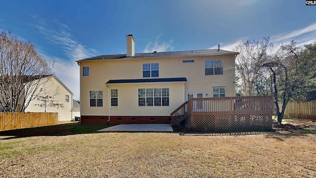 back of property featuring fence, a patio area, a chimney, a yard, and crawl space