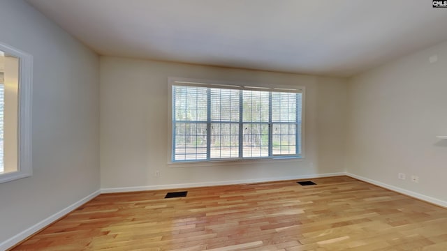 spare room featuring visible vents, baseboards, and light wood-style floors