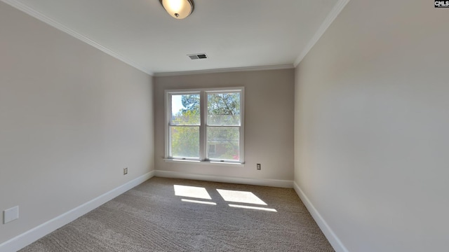 carpeted spare room featuring crown molding, baseboards, and visible vents