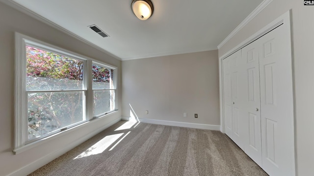 unfurnished bedroom with a closet, carpet floors, baseboards, and ornamental molding