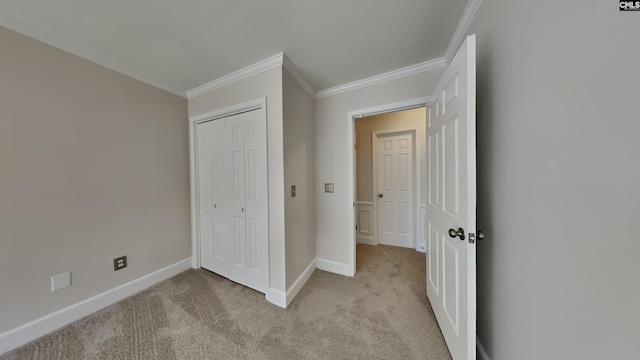 unfurnished bedroom with light colored carpet, baseboards, a closet, and ornamental molding