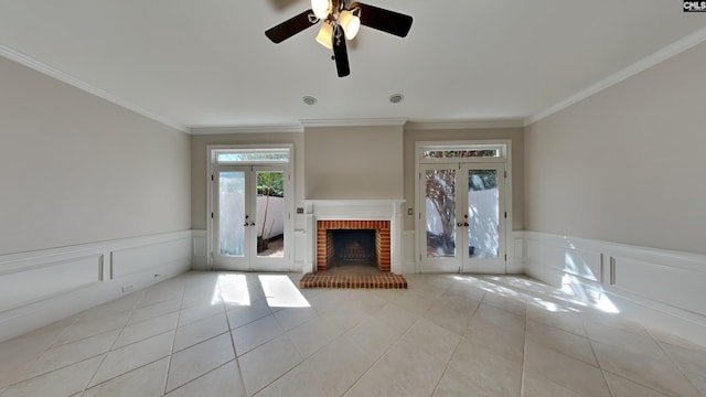 unfurnished living room with crown molding, light tile patterned floors, french doors, and wainscoting