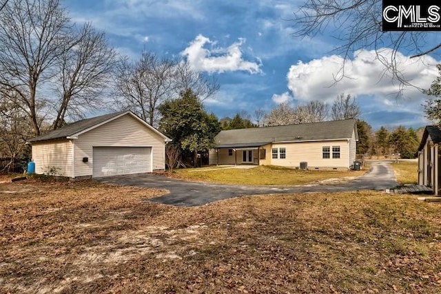 view of front of home featuring crawl space, a front lawn, a detached garage, and an outbuilding