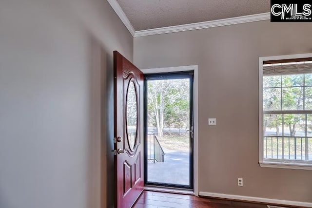 foyer featuring a textured ceiling, a healthy amount of sunlight, wood finished floors, and crown molding