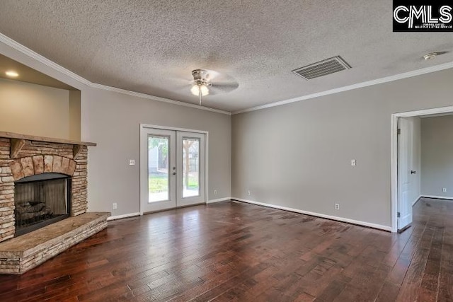 unfurnished living room with visible vents, french doors, a stone fireplace, and wood finished floors