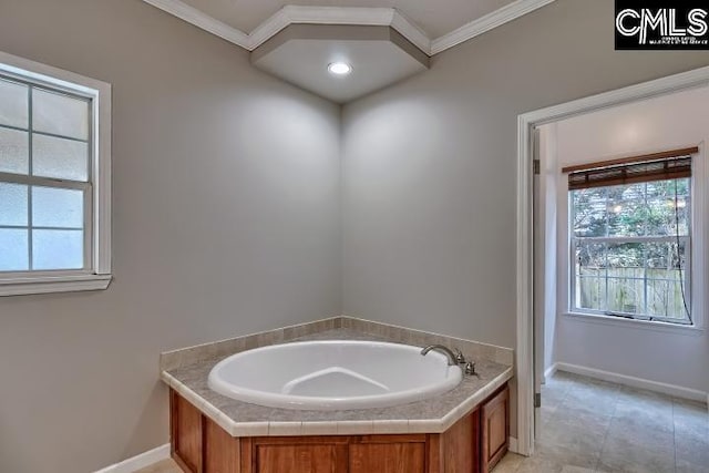 bathroom with tile patterned flooring, a garden tub, baseboards, and ornamental molding