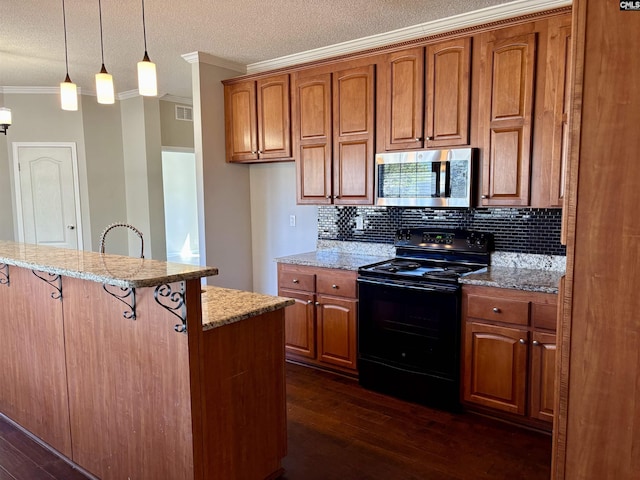 kitchen featuring stainless steel microwave, crown molding, a kitchen breakfast bar, brown cabinetry, and black electric range oven