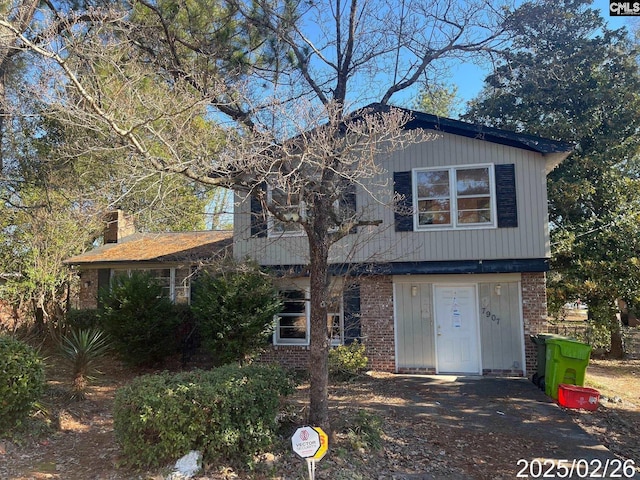 view of front of property featuring brick siding and a chimney