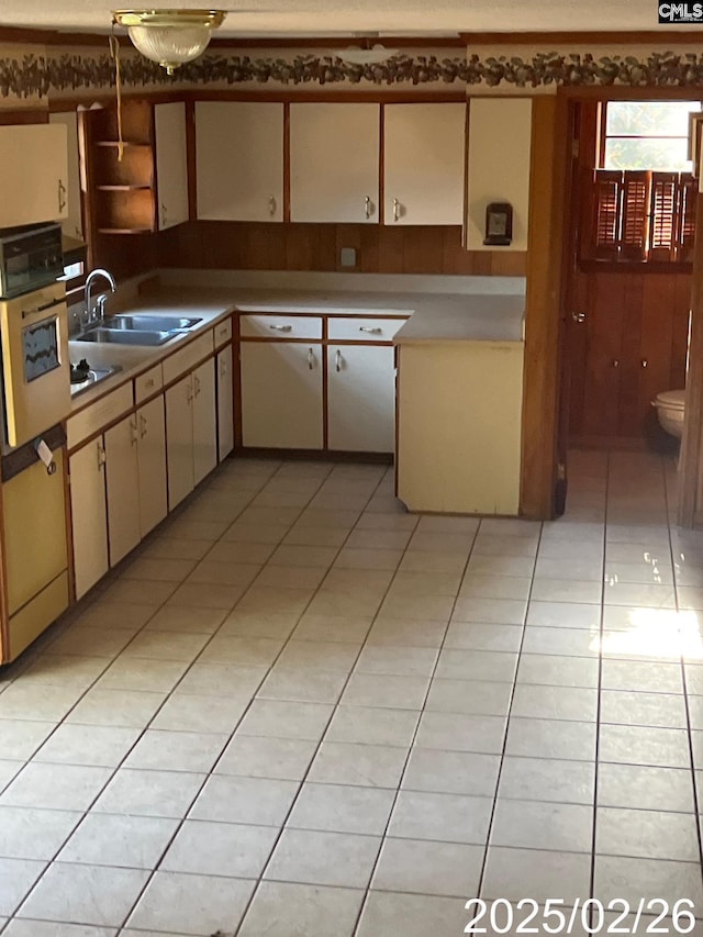 kitchen featuring a sink, light tile patterned flooring, and light countertops