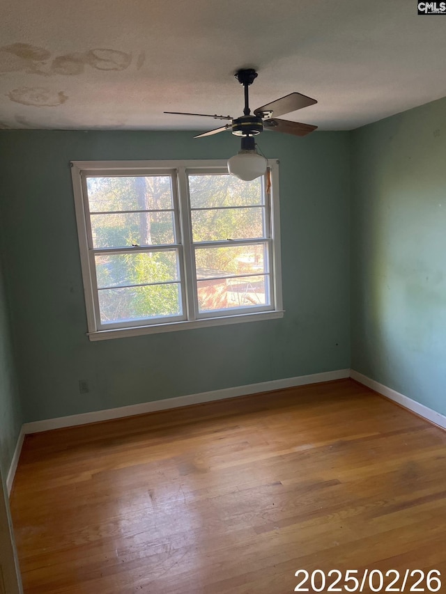 spare room featuring baseboards, a textured ceiling, wood finished floors, and a ceiling fan