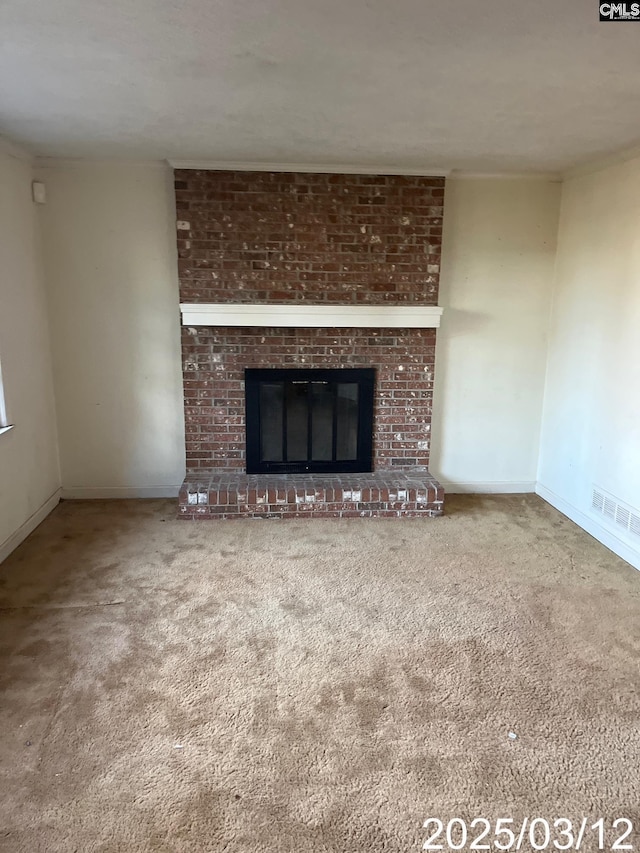 unfurnished living room with visible vents, carpet floors, baseboards, and a fireplace