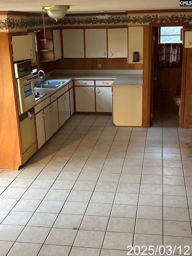 kitchen featuring a sink, oven, and light tile patterned floors