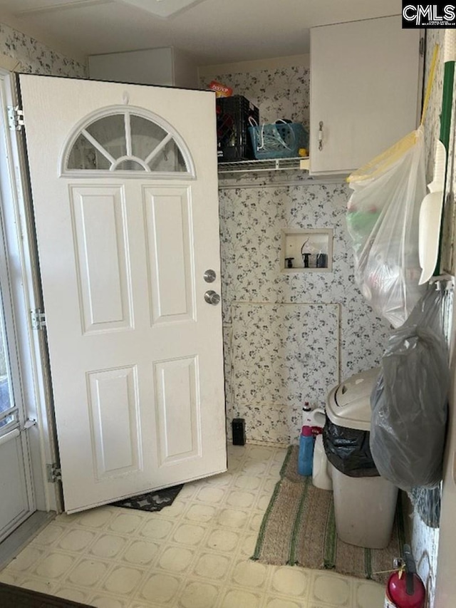 laundry area featuring wallpapered walls, laundry area, and tile patterned floors