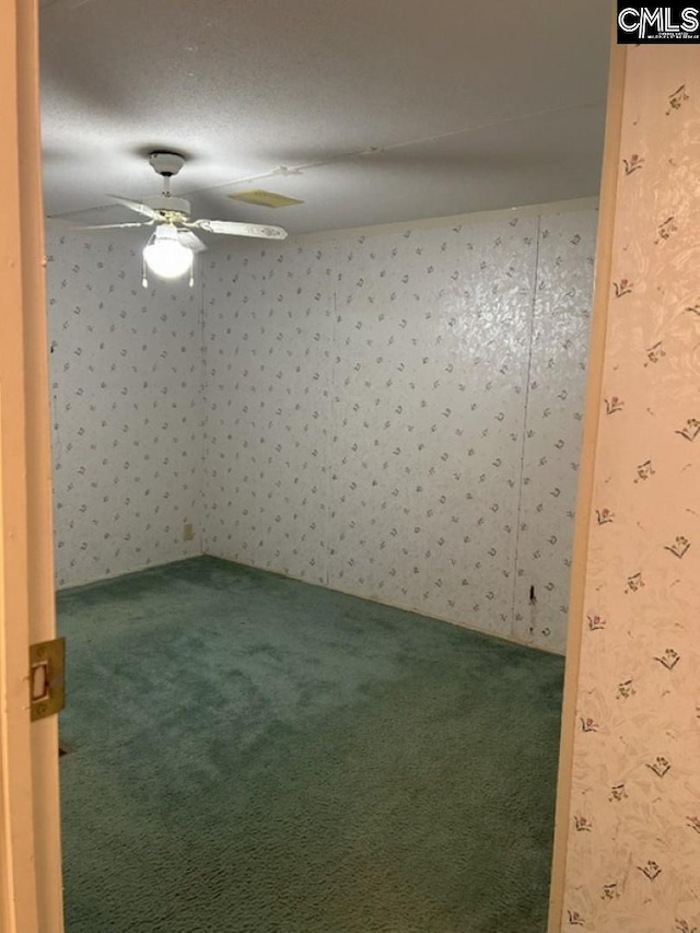 spare room featuring ceiling fan, wallpapered walls, and carpet