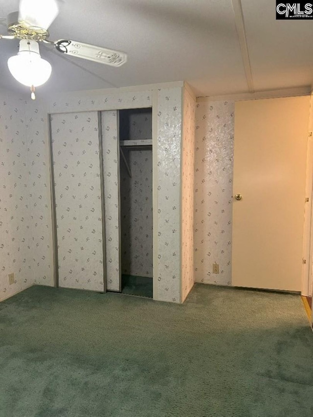 unfurnished bedroom with carpet flooring, wallpapered walls, and a ceiling fan