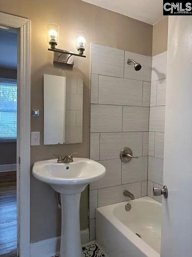 bathroom with shower / washtub combination and baseboards