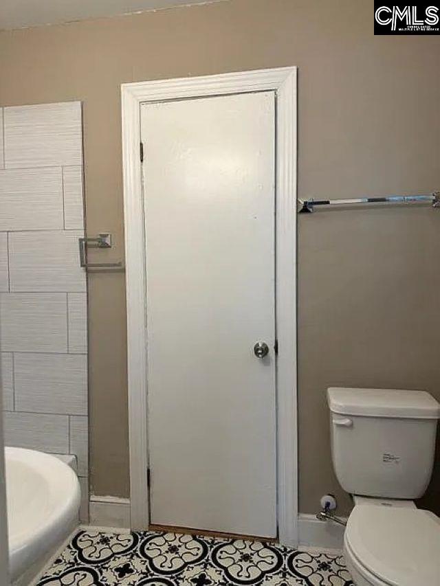 bathroom featuring toilet and baseboards