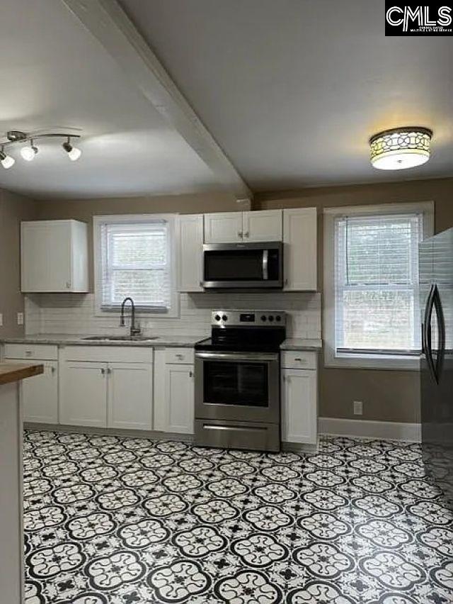 kitchen featuring white cabinetry, light countertops, and stainless steel appliances