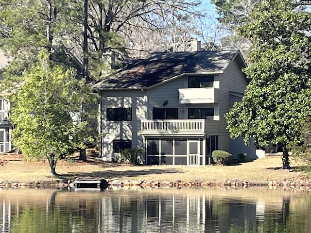 rear view of house with a balcony and a water view