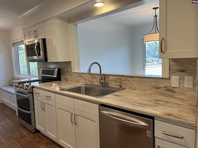 kitchen with a sink, appliances with stainless steel finishes, white cabinets, and light countertops