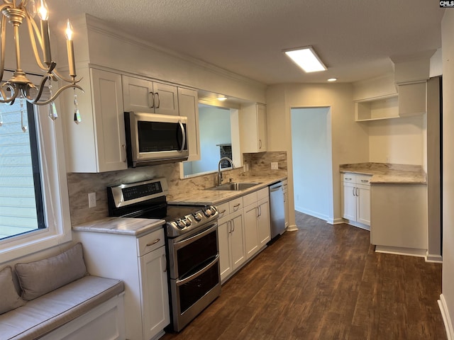 kitchen with a sink, open shelves, appliances with stainless steel finishes, and light countertops