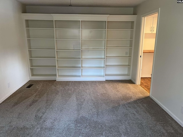 interior space featuring carpet flooring, baseboards, and visible vents