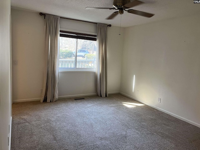 carpeted spare room featuring visible vents, baseboards, a textured ceiling, and a ceiling fan