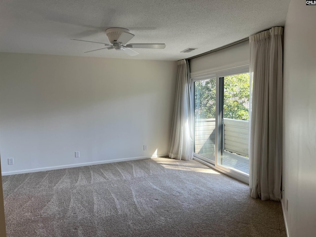 carpeted spare room featuring baseboards, a ceiling fan, visible vents, and a textured ceiling