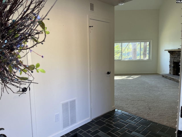 interior space featuring dark colored carpet, visible vents, and baseboards