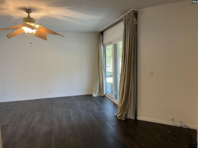 empty room featuring ceiling fan, a textured ceiling, dark wood-type flooring, and baseboards