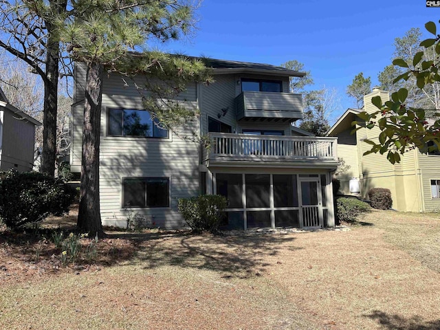 rear view of property with a balcony and a sunroom