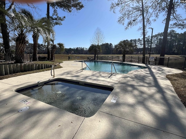 community pool with a patio and fence