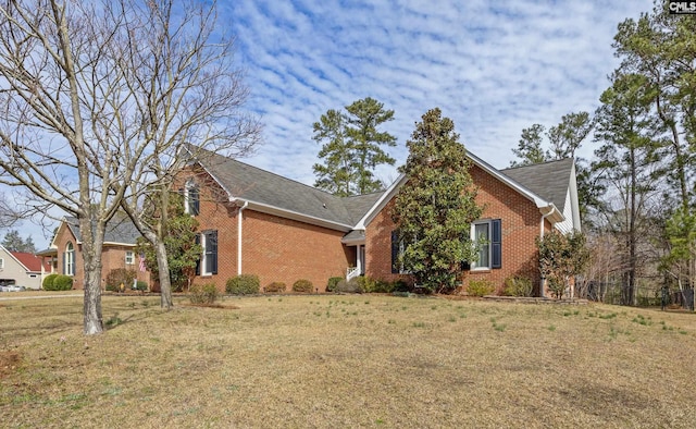 view of front of home with brick siding and a front yard