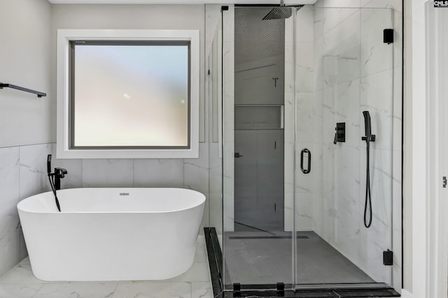 bathroom featuring a marble finish shower, a freestanding bath, and marble finish floor