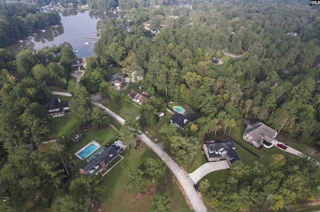 birds eye view of property with a view of trees and a water view