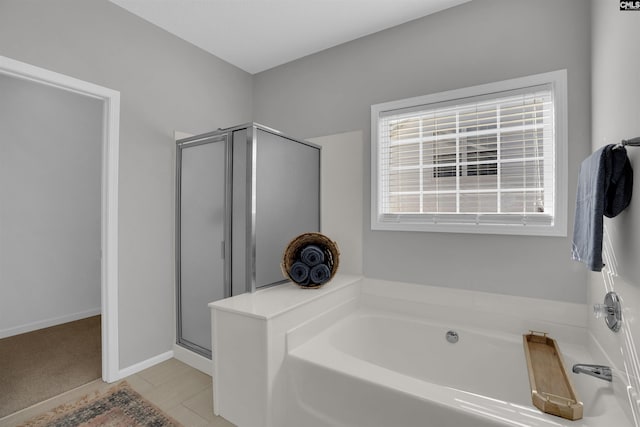 full bathroom featuring a garden tub, baseboards, and a stall shower