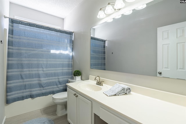 bathroom featuring a textured ceiling, vanity, and toilet