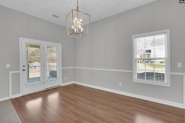 unfurnished dining area featuring dark wood finished floors, plenty of natural light, and baseboards