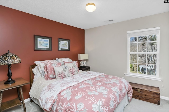 carpeted bedroom featuring visible vents and baseboards