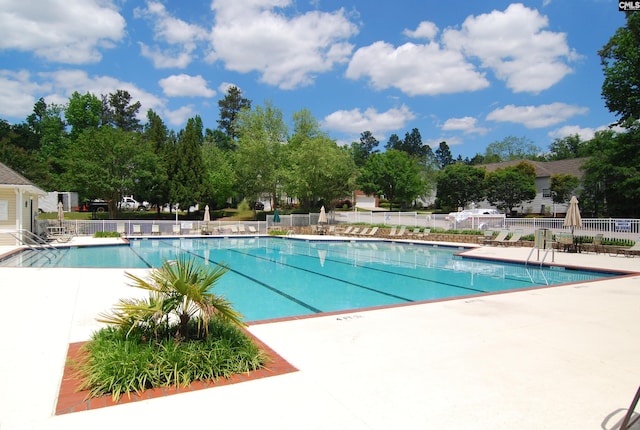 community pool featuring a patio and fence