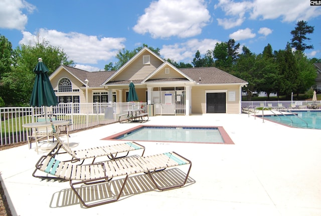 pool with a patio and fence