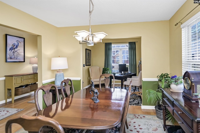 dining room featuring a wealth of natural light, light wood-type flooring, and a chandelier