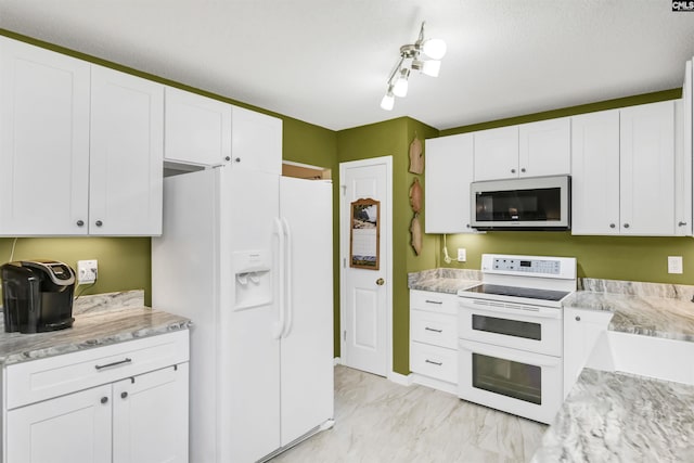 kitchen with white appliances, marble finish floor, white cabinets, and light stone countertops