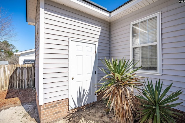 doorway to property featuring fence